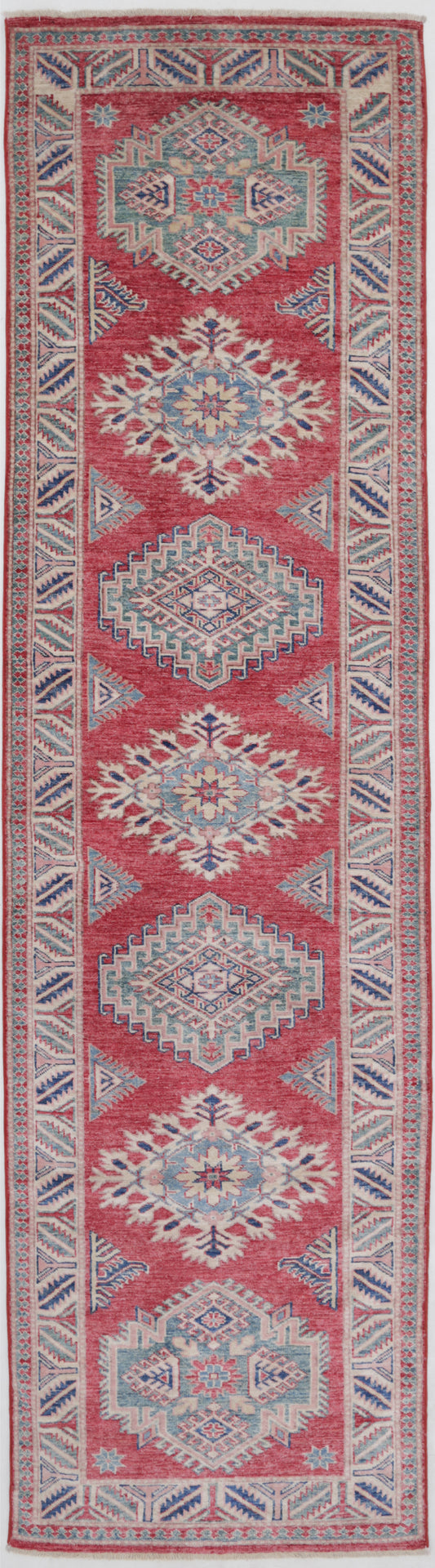 New Tribal Kazak hand-knotted wool rug 2'6" x 9'10" (76 x 300 cm) in red, from Artemis Rugs in Carmel, CA. Authentic handmade Kazak wool runner featuring bold tribal geometric patterns and traditional Caucasian designs. Crafted with high-quality, durable wool fibers using expert hand-knotting techniques. This vibrant red Kazak runner offers rich texture and genuine artisan craftsmanship, ideal for collectors and enthusiasts of authentic handmade tribal wool rugs