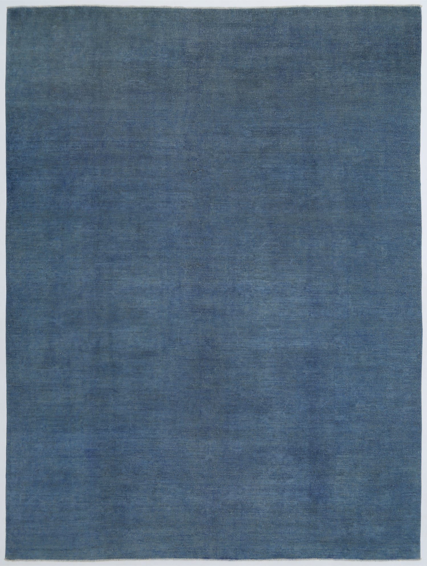 New Transitional Overdye hand-knotted wool rug 8'9" x 11'6" (267 x 351 cm) in blue, from Artemis Rugs in Carmel, CA. Authentic handmade wool rug featuring a unique overdye technique with soft, muted blue tones blending vintage and contemporary styles. Crafted with high-quality, durable wool fibers using expert hand-knotting techniques. This blue Transitional Overdye rug offers rich texture and exquisite artisan craftsmanship, ideal for collectors and lovers of distinctive handmade wool rugs."